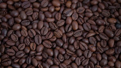 Fototapeta premium Closeup of roasted coffee beans, Rich textured roasted coffee beans with glossy finish, Closeup shot highlighting dark textured roasted coffee beans and reflections