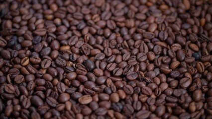 Fototapeta premium Coffee bean details, Shiny roasted coffee beans closeup, Close view of glossy brown coffee beans, Detailed perspective of rich chocolatecolored roasted coffee beans