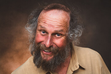 Fototapeta premium Schrulliger bärtiger Mann mit schelmischem Lächeln – humorvolles Charakterportrait