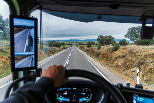 View from inside a truck of a straight road that disappears into the horizon.