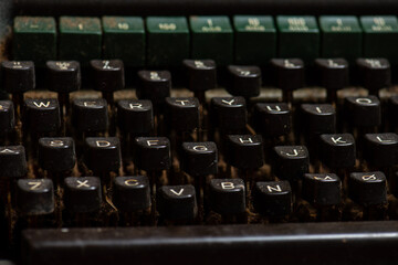 Vintage typewriter keyboard with worn black keys.