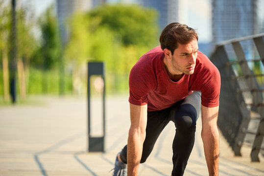 Determined man preparing to run on urban path
