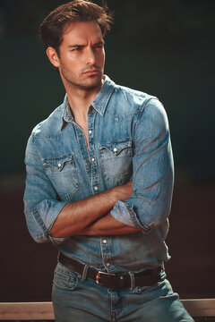 Confident man in denim shirt posing with crossed arms