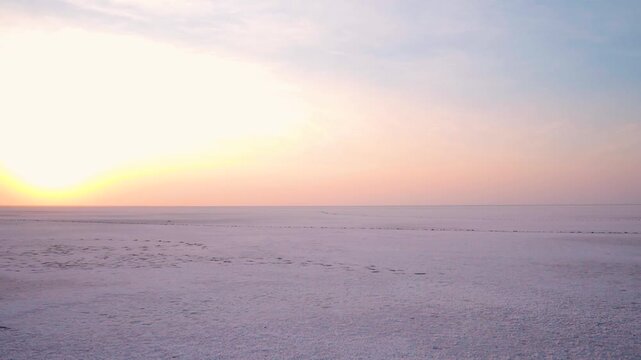 Wide angle shot of White desert of Kutch during the sunrise at Rann of Kutch in Kutch district, Gujarat, India. Scenic view of orange clouds in the sky during sunrise. Natural background.