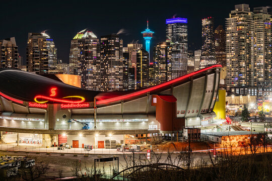 Calgary, Alberta, Canada &ndash; January 18, 2026: Downtown at night, featuring the tower lit in blue and the Scotiabank Saddledome in the foreground. The dome is scheduled to be replaced by a new arena.