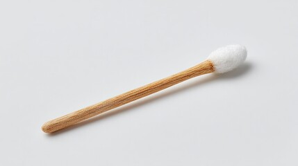 Naklejka premium Cotton swab made of wood rests on a white surface. It's a hygiene item.