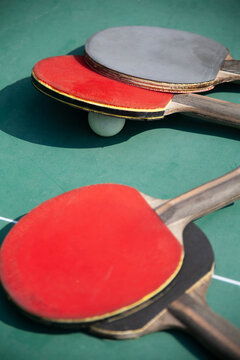 $ table tennis bats and a ping pong ball on a table