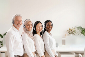 Obraz premium Diverse call center team with headsets smiling in a modern office