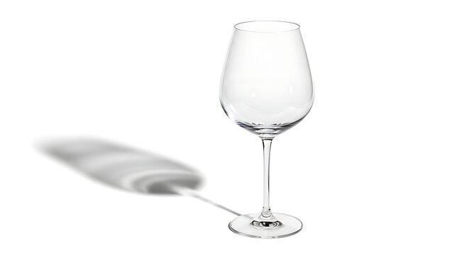 Clear wine glass stands with shadow on white surface viewed directly