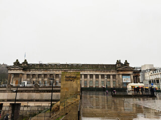 Obraz premium National Gallery building in Edinburgh, Scotland, UK on a rainy day with neoclassical facade and wet reflective city square