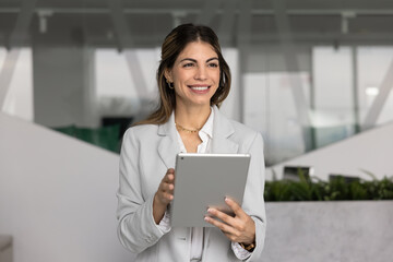 Confident smiling Hispanic female professional project manager executive in formal suit distracted...