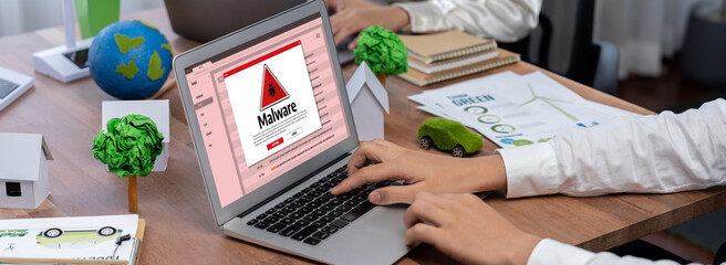 Cyber attacking concept. Malware alert showing on computer screen display scam and threat detection on computer system or online server to be removed brisk. © InfiniteFlow