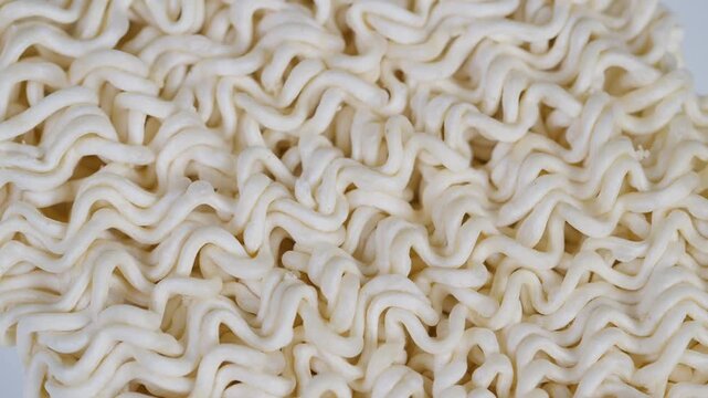 Close up instant noodles texture uncooked macro study revealing dry ramen strands, repeating wavy pattern, beige tones, visible starch granules, tactile appeal, pantry staple focus