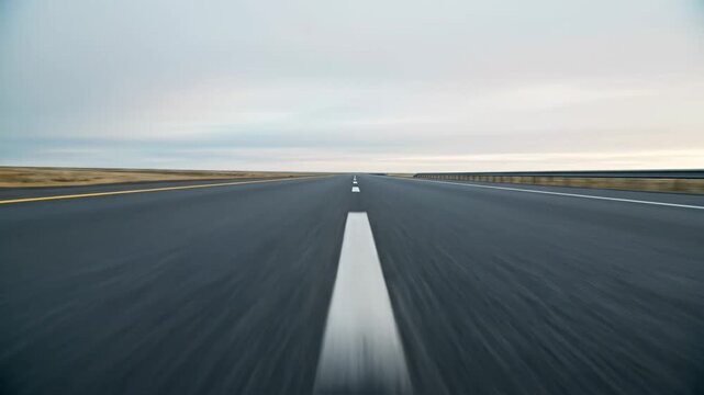 Car driving point of view on a fast empty road