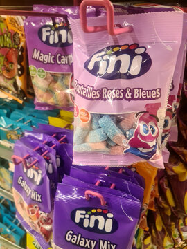 Colorful candy packages displayed on a store shelf. Various flavors and shapes are visible, showcasing vibrant colors and playful designs. Fini