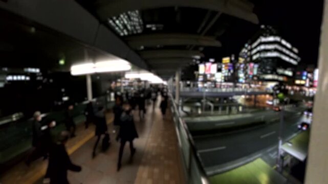 TOKYO, JAPAN - FEB 2026 : Blurred view of crowd of people walking at the busy station in night time rush hour. Many commuters going home. Japanese business people, job and lifestyle concept.