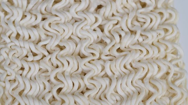 Highresolution closeup revealing wavy noodle texture for packaging. Detailed macro shot showcasing intricate surface of compact dried instant noodles for culinary applications