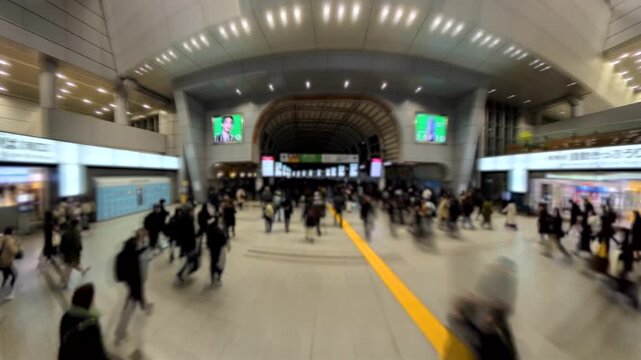 TOKYO, JAPAN - FEB 2026 : Blurred time lapse shot of crowd of people walking at the busy station in night time rush hour. Many commuters going home. Japanese business people and lifestyle concept.