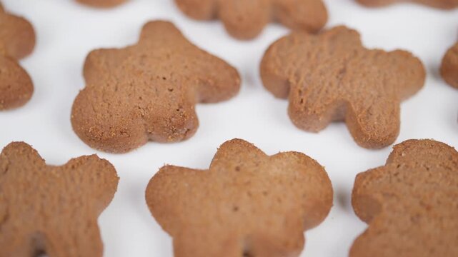 Decorative biscuits on white background. Warm brown gingerbread with fine spice details captured softly. Closeup image of delicate cookies with cozy and inviting seasonal feel