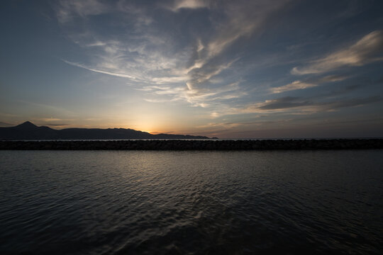 Beautiful synset behind mountains by the sea. Blue hour on an island. 
