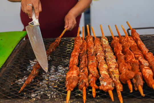 Latin woman entrepreneur grilling anticuchos street food
