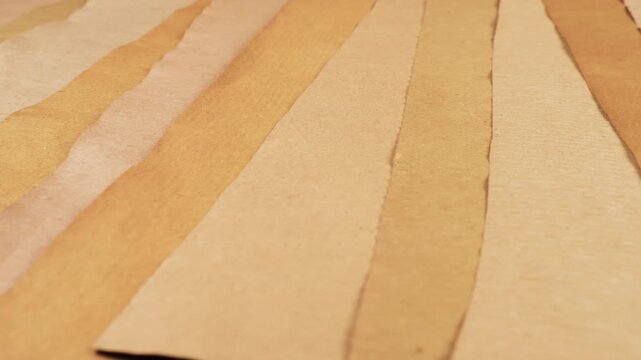 Handmade recycled paper background in beige, tan, and cream colors. Natural eco-friendly textured surface for craft and DIY projects. Vintage aged paper strips with natural plant-based dyes.