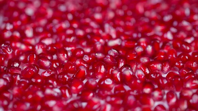 Vivid fruit imagery. Closeup of glossy ruby seeds. Macro shot highlighting vibrant pomegranate arils. Detailed image showcasing shiny red seeds with soft focus background