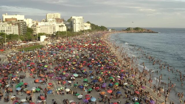 Drone, aerial view of huge crowds of beachgoers partying on the beach of Ipanema during Carnival in Rio de Janeiro.
