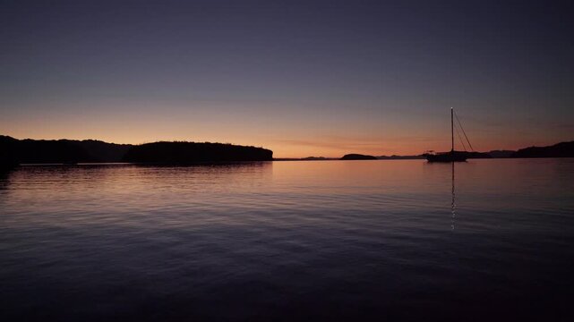 Early morning ocean surface sailboat 
