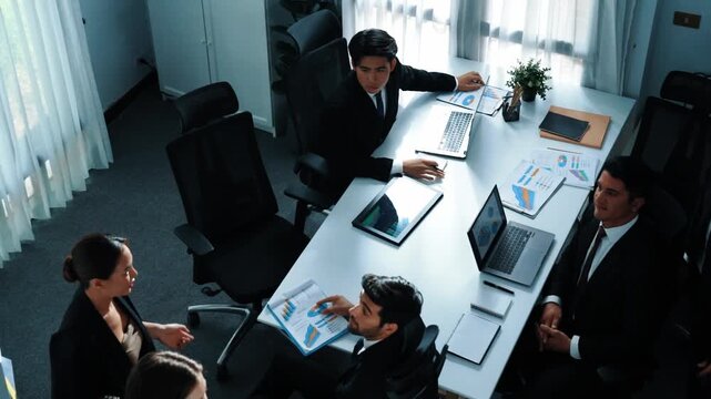 Top view of smart executive manager financial graph to diverse team while group of multicultural business people planning marketing strategy by using stock investment chart at meeting. Directorate.