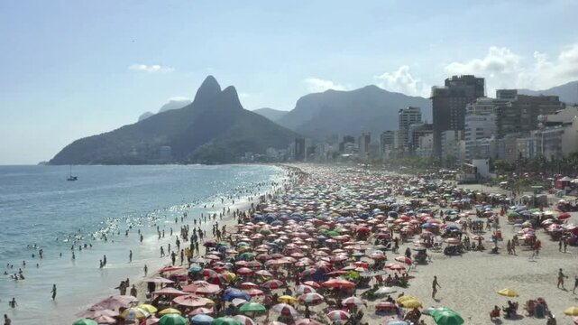 Drone, aerial shot of a huge crowds of beachgoers on the sunny day over Ipanema beach in Rio de Janeiro.