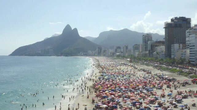 Drone flying over huge crowds of beachgoers over Ipanema and Leblon in Rio de Janeiro.