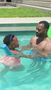 Father holding son in backyard pool, guiding arm strokes with animated safety guides for learning