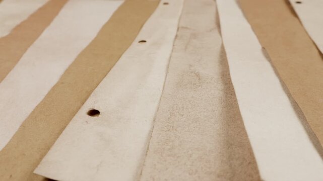 Vintage handmade paper strips in cream and beige colors. Textured recycled craft background with natural plant dyes. Abstract closeup of aged parchment surface for scrapbooking.