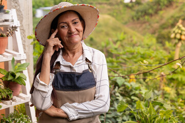 Thoughtful senior woman gardener looking the camera tipical rutal life Colombian horizontal medium shot