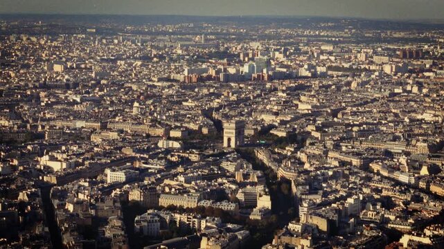 Evoking Parisian charm and nostalgia an aerial view of Paris with the Arc de Triomphe shot in a Super 8 film style The blurry handheld retro-film aesthetic adds a stylish and vintage feel to the citys