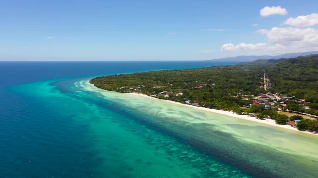 Tropical sandy beach with palm trees and turquoise clear waters. Bohol, Anda, Philippines.