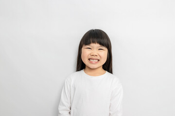 Obraz premium Adorable little girl showing her teeth in a smile