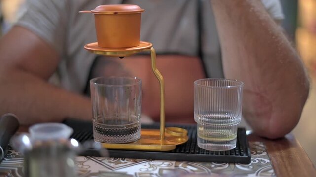 Vietnamese Phin Set On Tray With Two Glasses, Metal Filter Poised Above Empty Glass, Traveler Hands Resting Nearby, Relaxed Tasting Moment At Cafe Counter, Vivid Foreground Detail With Soft
