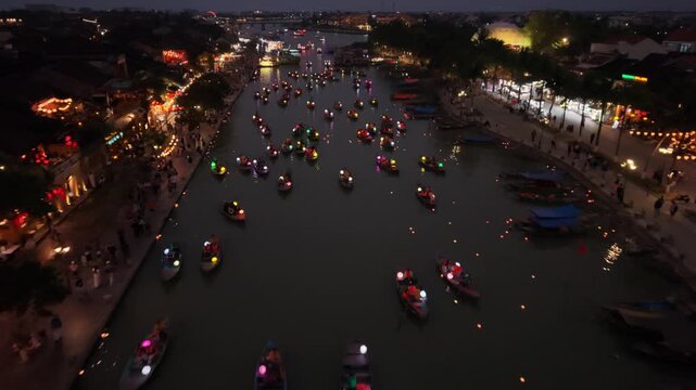 Aerial River Procession Vietnam With Hundreds Of Lanterned Boats And Asian Passengers, Soft Reflections And Tranquil Mood As Glowing Orbs Drift Toward Distant Waterfront Lights