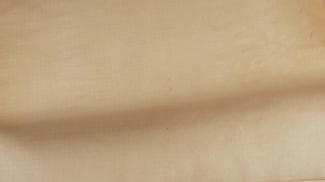 Natural handmade paper in earthy beige and soft tan tones being stacked one by one. The organic texture of this recycled craft material creates a beautiful vintage backdrop.