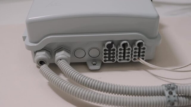 Fiber Optic Distribution Box with Cables Installed Indoors | Close-Up Bottom View of Network Junction Box with Connectors and Cable Entries | Telecom Infrastructure