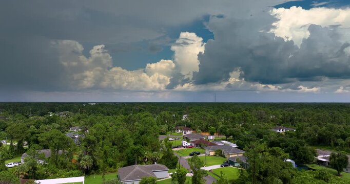 Heavy downpour from thick storm clouds over Florida rural town. Intense summer rainstorm in tropical atmosphere.