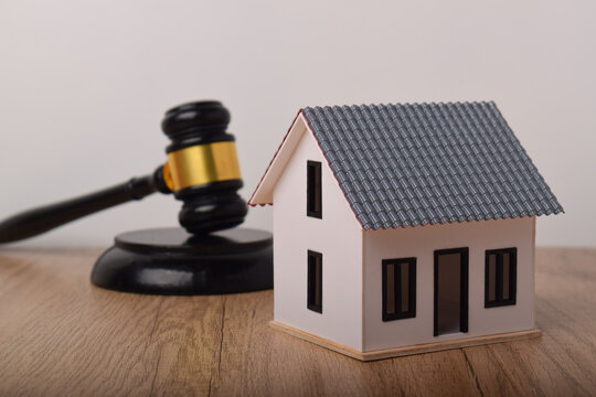 Judge gavel with a miniature house. Concept for real estate litigation, property law, court rulings, and housing auction.