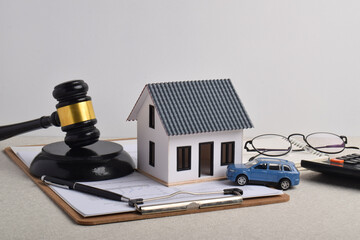 Judge gavel, house model, car, financial documents, and calculator. Concepts for property law, asset ownership, mortgage planning, and legal decisions affecting real estate and personal assets. © Mulad Images