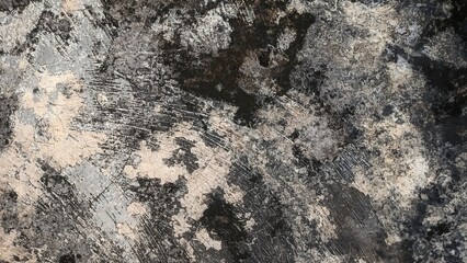 The wall surface looks dirty and peeling, covered in black stains, white spots, and scra