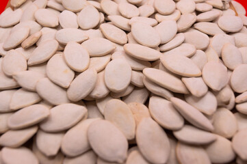 Whole Pumpkin Seeds in Shell Isolated, Raw Pepita Grains, Scattered Green Healthy Nuts, Pumpkin Seed with Skin on White Background Top View