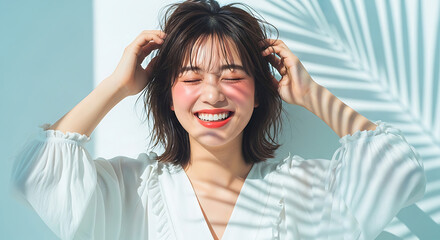 Naklejka premium a joyful young asian woman with closed eyes and a wide smile enjoying summer sun rays with palm leaf shadows against a light blue wall