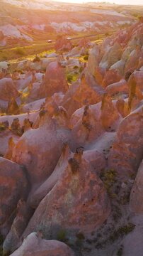 Vertical video. Goreme, Nevsehir, Turkey. Serene evening view of Devrent Valley with mystical rock formations and peaceful atmosphere during sunset meditation hours.. Aerial View. Rich colors