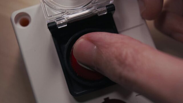 Hand Lifting Safety Cover and Pressing Red Heart Button Under Crimson Warning Light